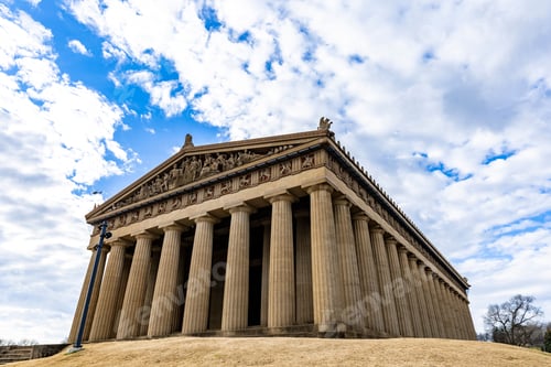 Preview: Low angle shot of the Parthenon in Nashville, Tennesee under a bright cloudy sky on a sunny day