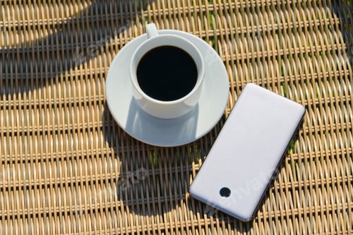Preview: Top view on cup of coffee and smartphone on wicker background