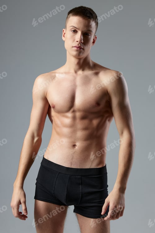 Preview: athletic male bodybuilder with pumped up abs black panties cropped view studio