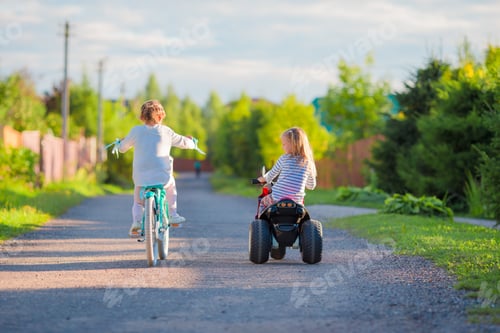 Preview: Happy little girls biking outdoors at the park