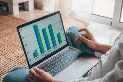 Preview: Close up rear view young woman using laptop and calculator, working on project