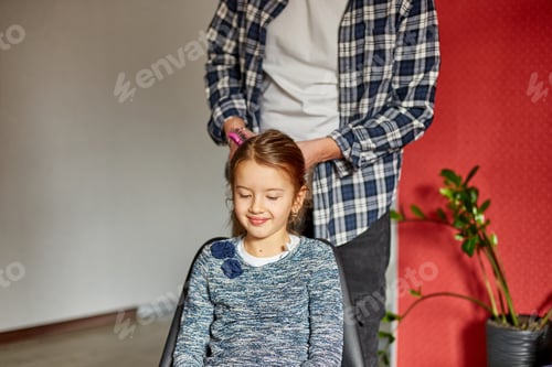 Preview: Father combing, brushing his daughter's hair at home