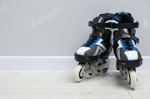 Preview: Pair of roller skates on floor near white wall, space for text
