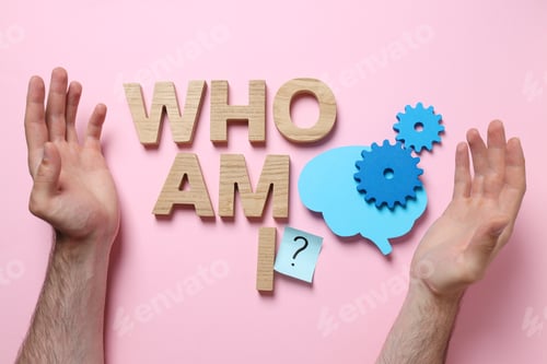 Preview: Text Who am I?, paper brain and man's hands on pink background, top view