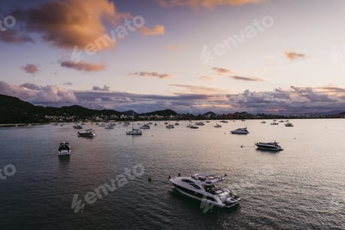 Preview: Many moored yachts off the coast at sunset.