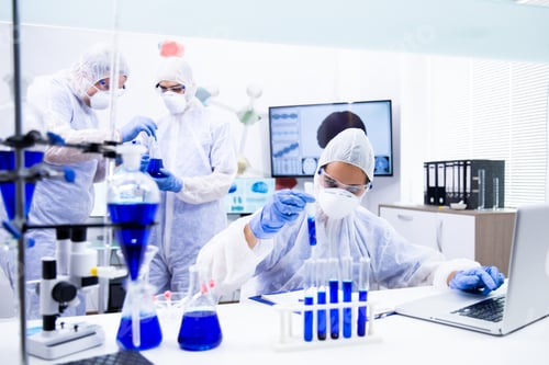 Preview: Young team of chemists examines a blue substance that is in the tube