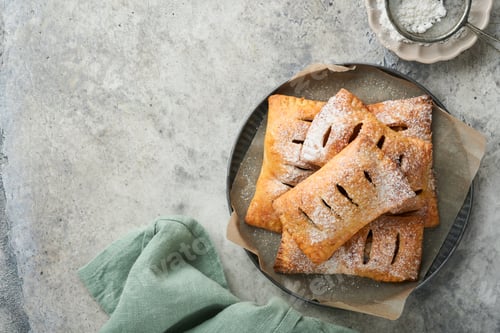 Preview: Hand pies. Mini puff pastry or hand pies stuffed with apple and sprinkle sugar powder in wooden plat