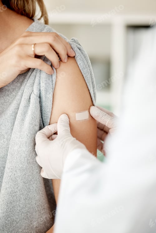 Preview: Covid, vaccine and injection with a doctor placing a plaster on the arm of a female patient in the