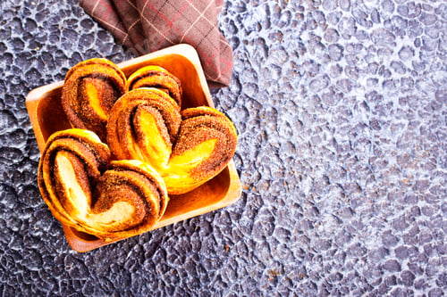 Preview: Freshly baked cinnamon rolls in wooden bowl