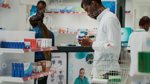 Preview: Young adult looking at packs of vitamins in drugstore
