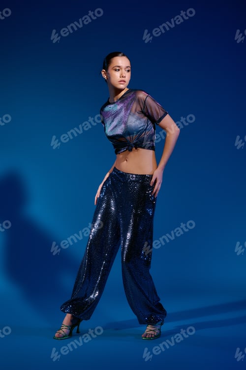 Preview: Stylish young woman showcases vibrant fashion in a striking studio setting