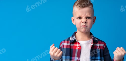 Preview: Portrait of angry little boy on blue background