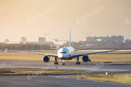 Preview: Wide-body passenger airplane taxing on runway after landing during sunset