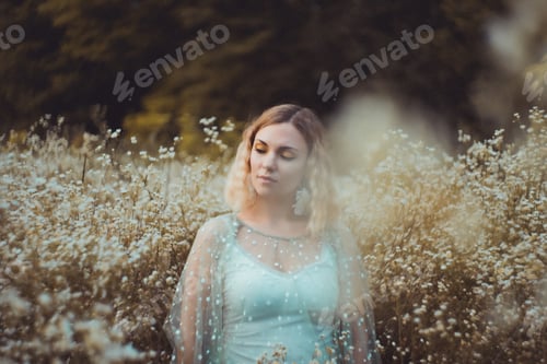 Preview: beautiful girl with wavy hair posing in chamomile field