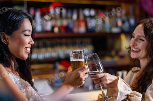 Preview: Two female friends enjoy a deep conversation over a glass of wine at a party