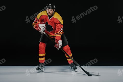 Preview: full length view of professional young ice hockey player playing hockey on black
