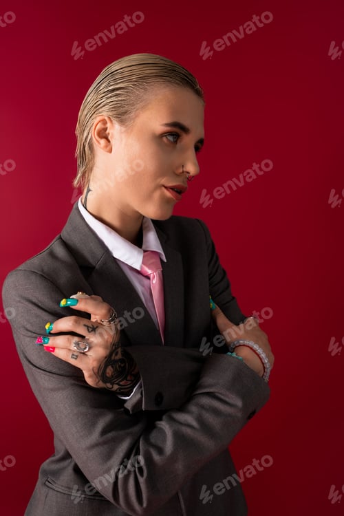 Preview: Stylish young woman with colorful nails exudes confidence against a vivid red background