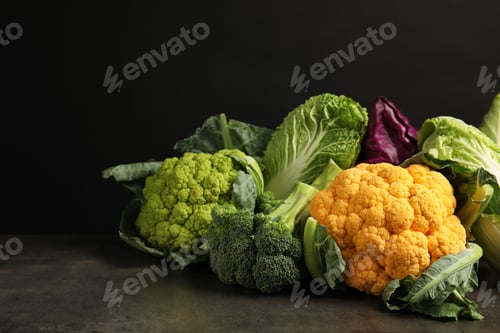 Preview: Different fresh cabbages on table against black background. Healthy food