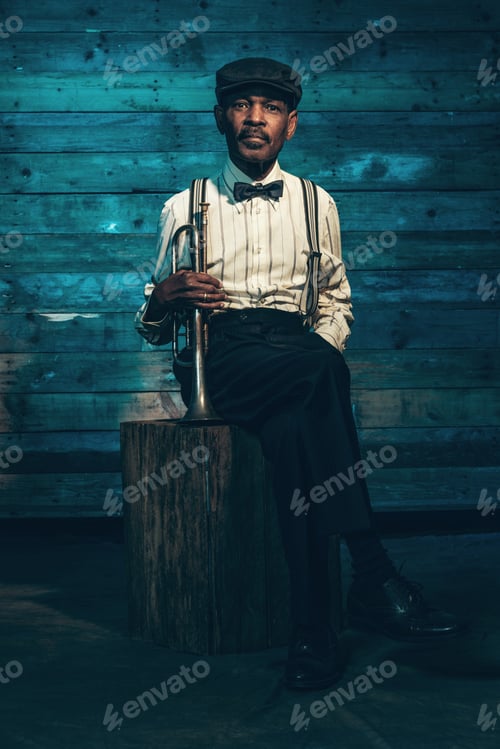Preview: Vintage African American Senior Jazz Musician With Trumpet In Front Of Old Wooden Wall. Wearing