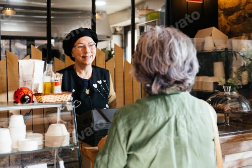 Preview: Smiling Shopkeeper Serving Takeaway Food to a Customer During Daytime