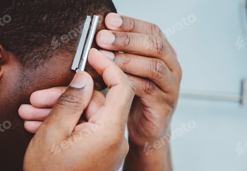 Preview: African American or black man at home shaving hair with razor blade