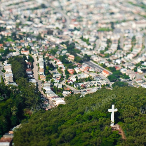 Preview: Urban sprawl with crucifix in park.