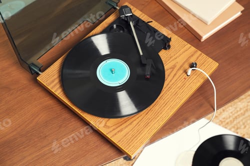Preview: Stylish turntable with vinyl discs and headphones in room, about view