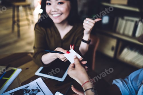 Preview: Crop smiling woman giving business card to woman
