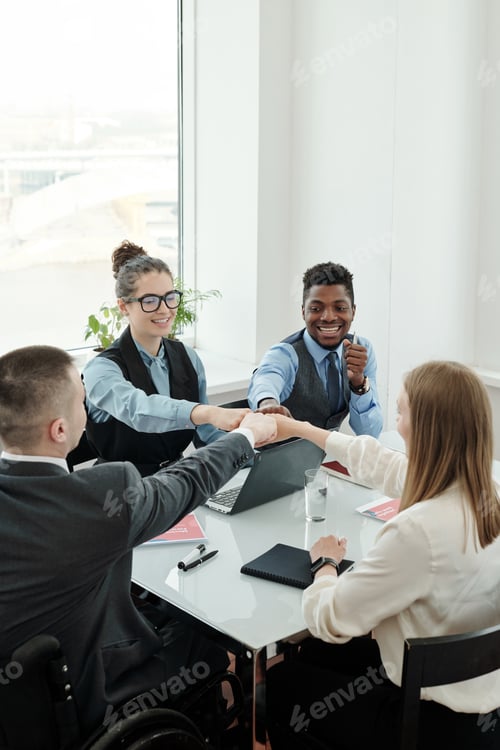 Preview: Group of intercultural business people making punch bump