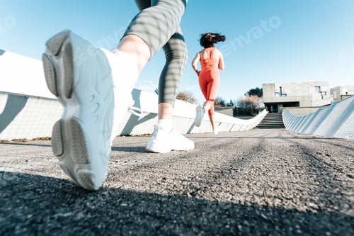Preview: Two young fitness woman training running outdoors doing exercise wearing sportswear. Fitness