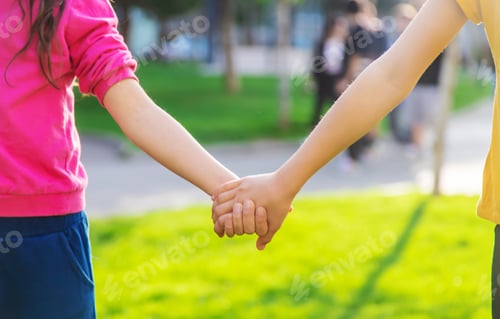 Preview: Children walk together holding hands. Selective focus.