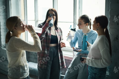 Preview: Group of Young Women Drinking Water by Large Windows