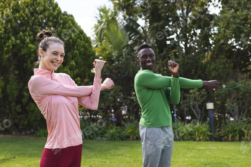 Preview: Portrait of happy diverse couple practicing yoga and stretching in garden