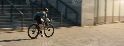 Preview: Professional female cyclist and protective gear riding bicycle
