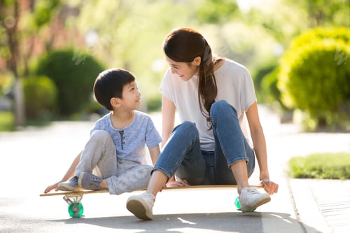 Preview: Chinese mother and son sitting on a skateboard