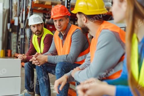 Preview: Successful workers, engineers wearing hard hats and work wear, factory foreman talking to colleagues