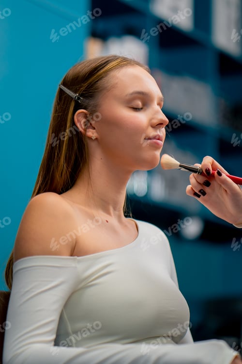 Preview: A make-up artist applies cosmetic blush with a brush to a client's face in a beauty salon