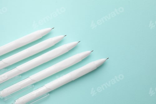Preview: White pens on light blue background, flat lay. Space for text