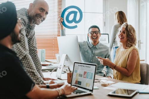 Preview: Employees in an office holding an at sign