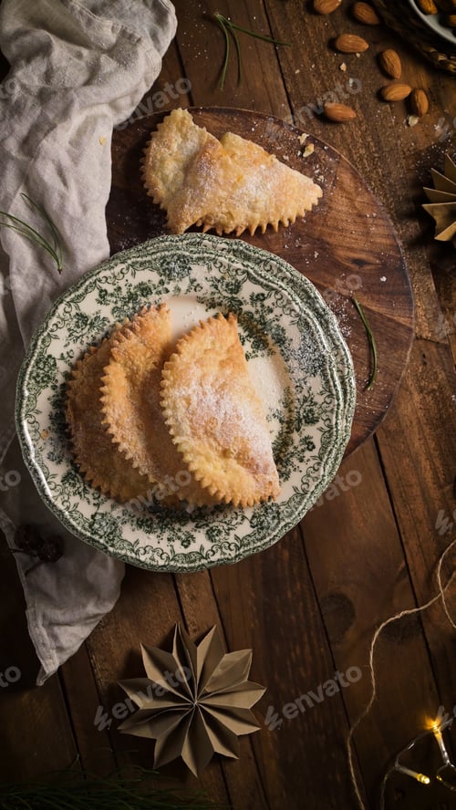 Preview: Three traditional Sardinian Seadas pastries dusted with powdered sugar on a vintage plate