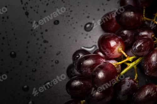 Preview: Close up of red grapes on black background with copy space