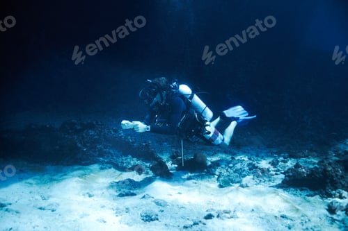 Preview: Male scuba diver floating just off the ocean bottom - Deep ocean diving
