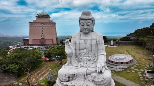 Preview: Peaceful Buddha statue overlooking a serene cemetery in Taiwan during a cloudy day