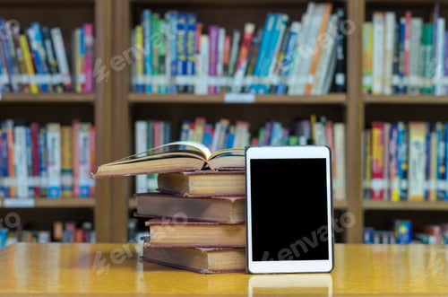 Preview: old book on the desk in library with tablet
