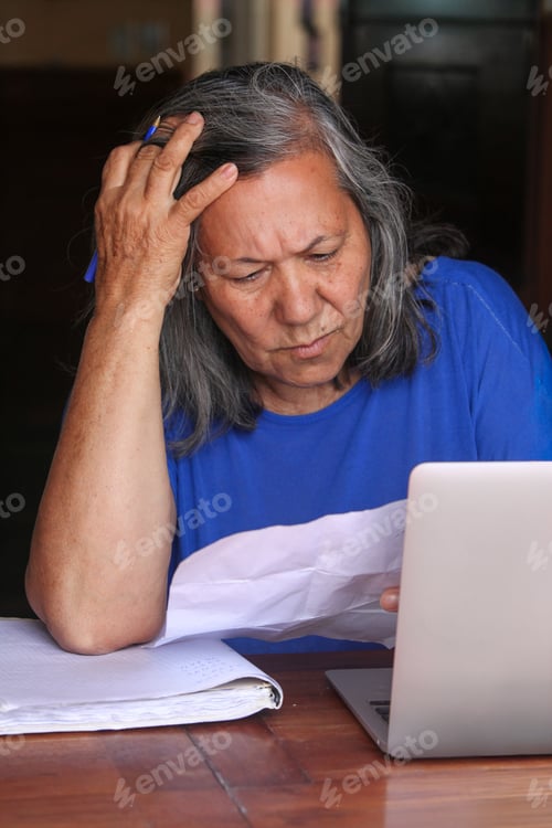 Preview: Senior Woman Using Laptop and Reading Documents at Home