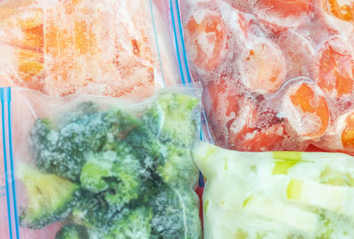 Preview: Packages with frozen vegetables close-up top view.