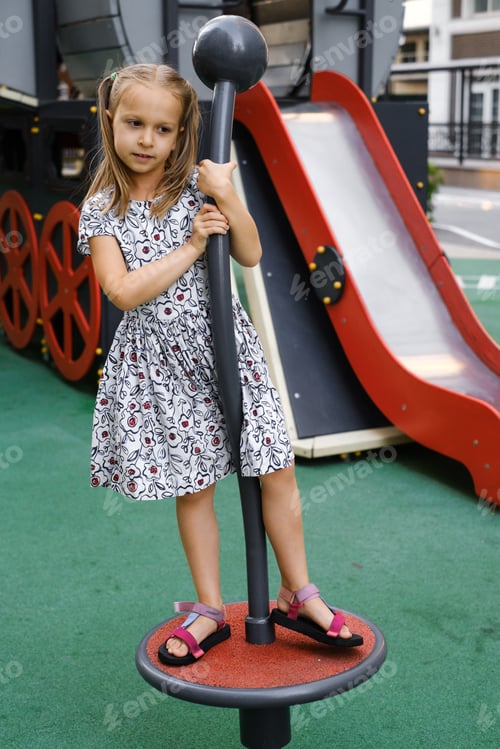 Preview: Child playing on the playground in the city in summer