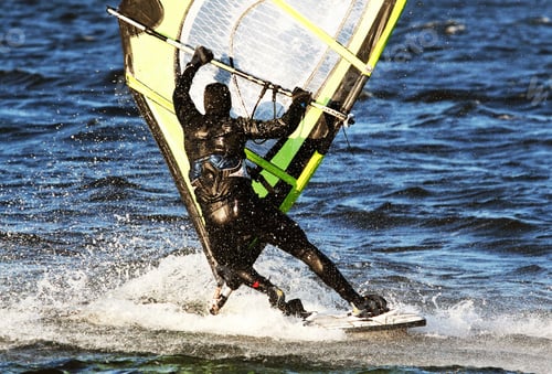 Preview: Closeup of a person in a swimming suit, windsurfing on a sunny day