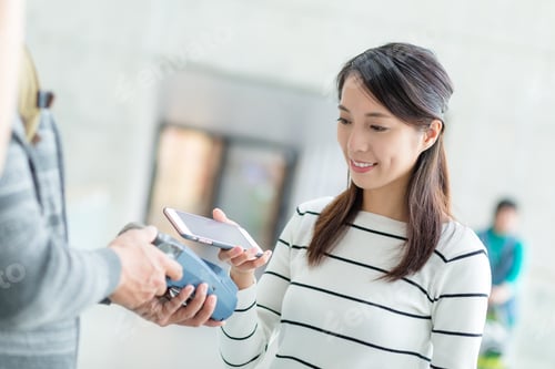 Preview: Woman usinf mobile phone to pay by NFC technology