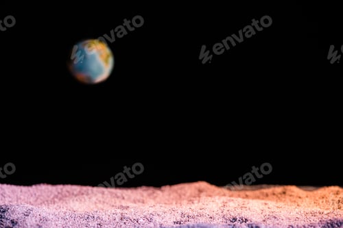 Preview: selective focus of textured ground with blurred planet Earth in space isolated on black